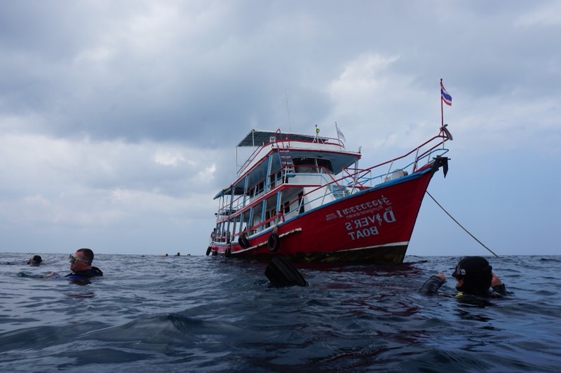 El barco de buceo en su fondeo bajo un cielo nublado.