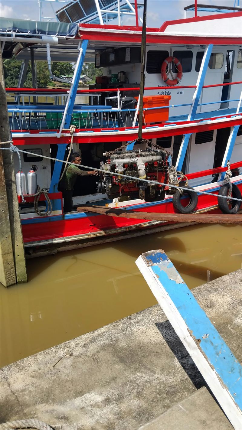 The new engine being lowered into the boat on chains at the shipyard.