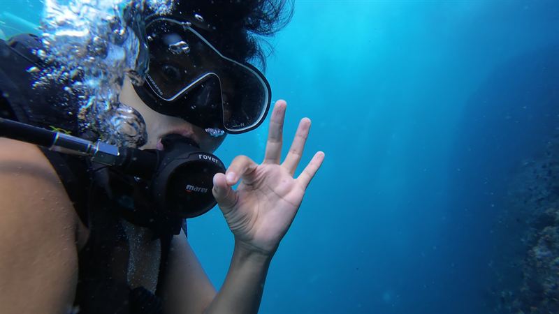 A diver giving the OK sign underwater.