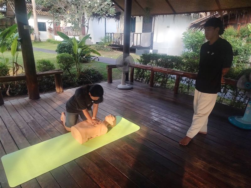 A student practising chest compressions on a CPR dummy.