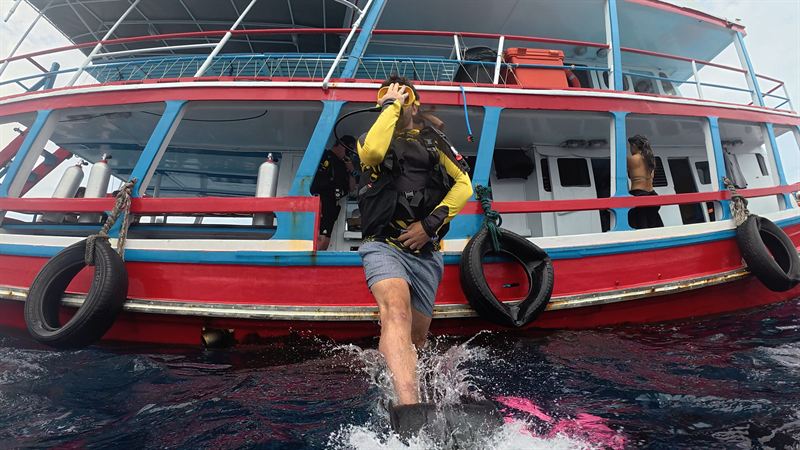 Un buceador entrando al agua con paso de gigante desde nuestro barco.