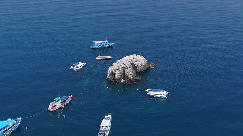 Dive boats moored around Sail Rock, seen from the air.